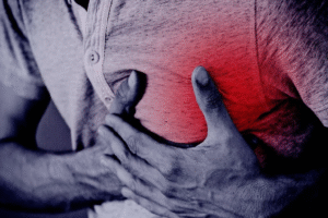 Persona con la mano en el pecho por dolor punzante en el corazón, posible síntoma leve de ansiedad o tensión muscular