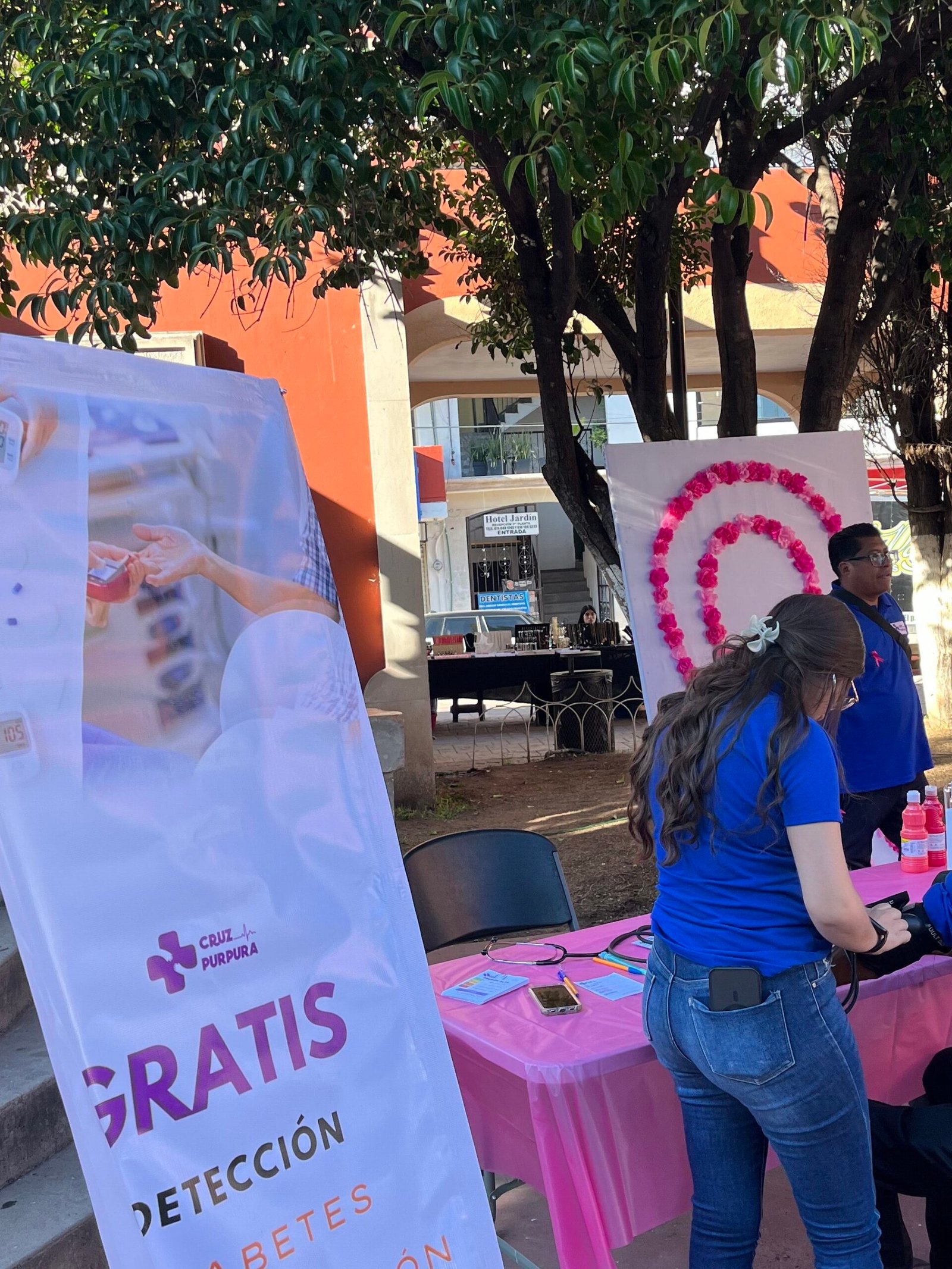 Médico de Cruz Púrpura realizando toma de presión gratuita a una asistente en la Kermés Rosa.