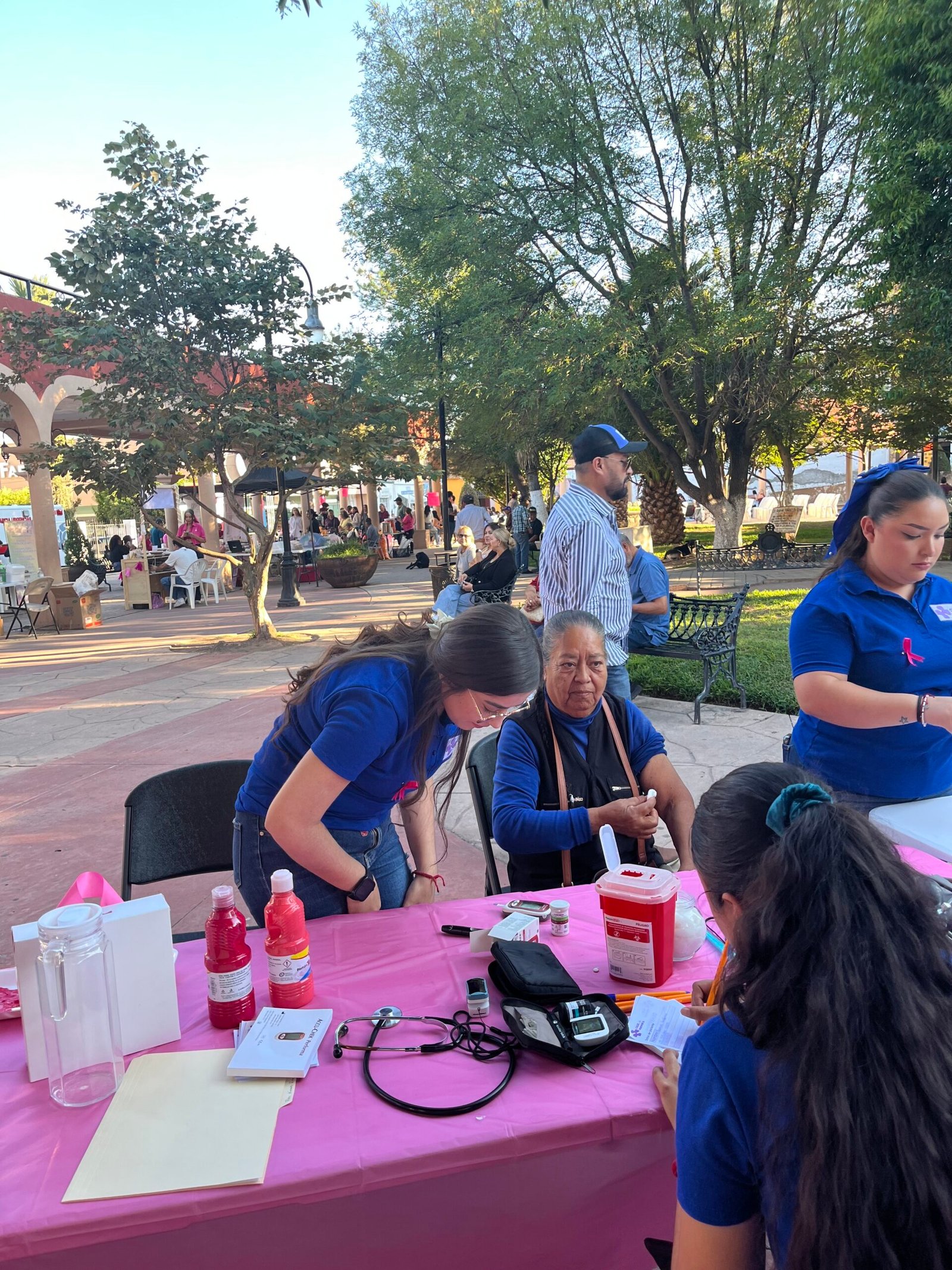 Médico realizando prueba de glucosa gratuita en la Kermés Rosa.
