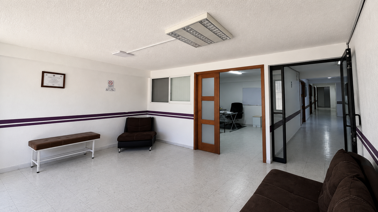 Sala de espera de Cruz Púrpura con mobiliario café, vista a un consultorio y un pasillo iluminado
