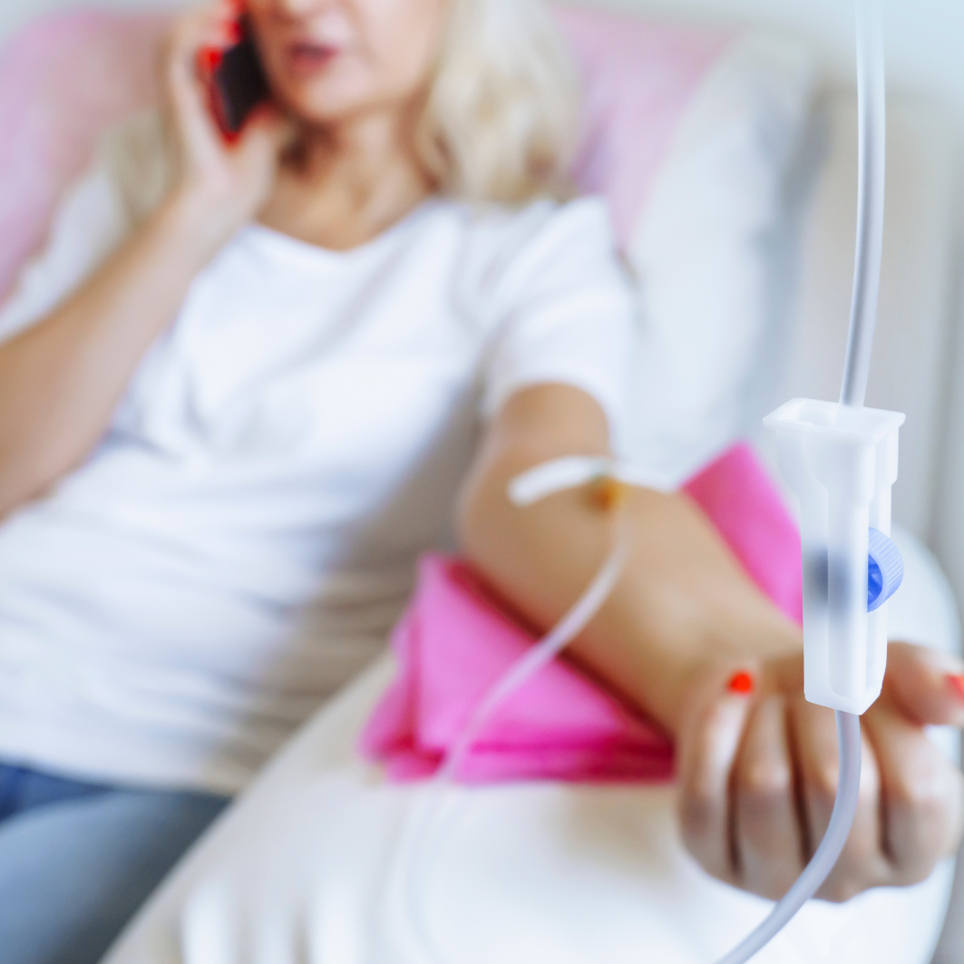 Detalle de la mano de un paciente con una vía intravenosa (suero) colocada y asegurada con apósitos profesionales .