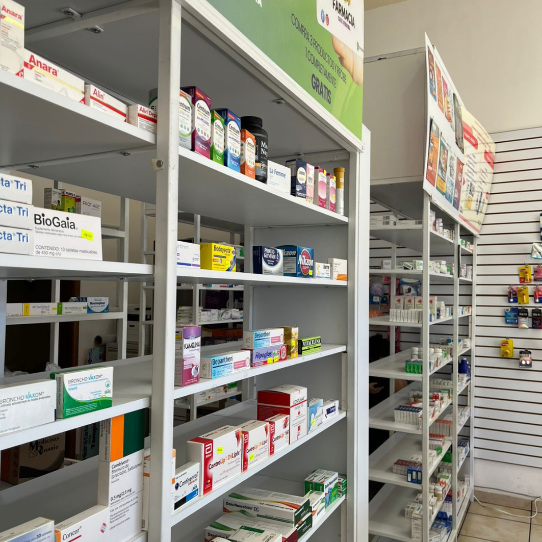 Estantería de Farmacia Cruz Púrpura con amplia variedad de medicamentos y productos de salud organizados.